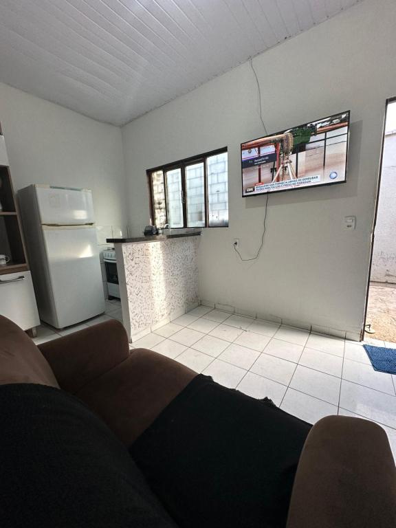 uma sala de estar com um sofá e uma televisão na parede em Flat Davisis 4 - Rodoviária Faculdades e Aeroporto em Palmas