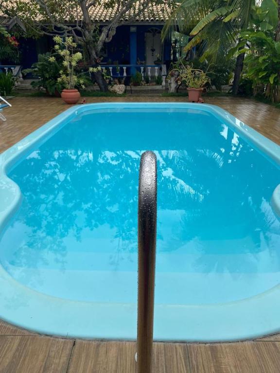 a large blue swimming pool with a pole in it at Cantinho dos Machados in Camaçari
