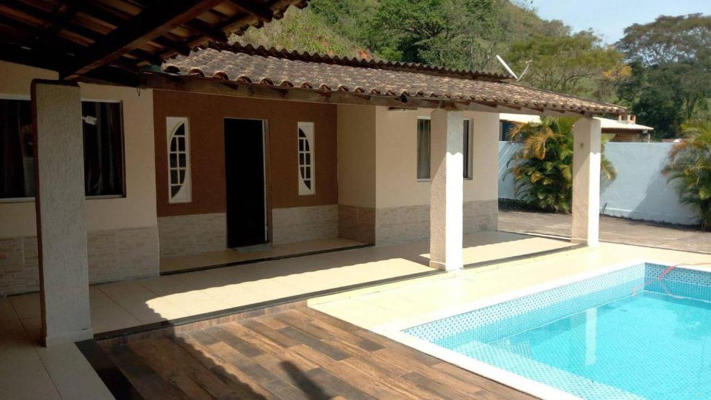 una casa con piscina frente a una casa en Casa morada na serra, en Macaé
