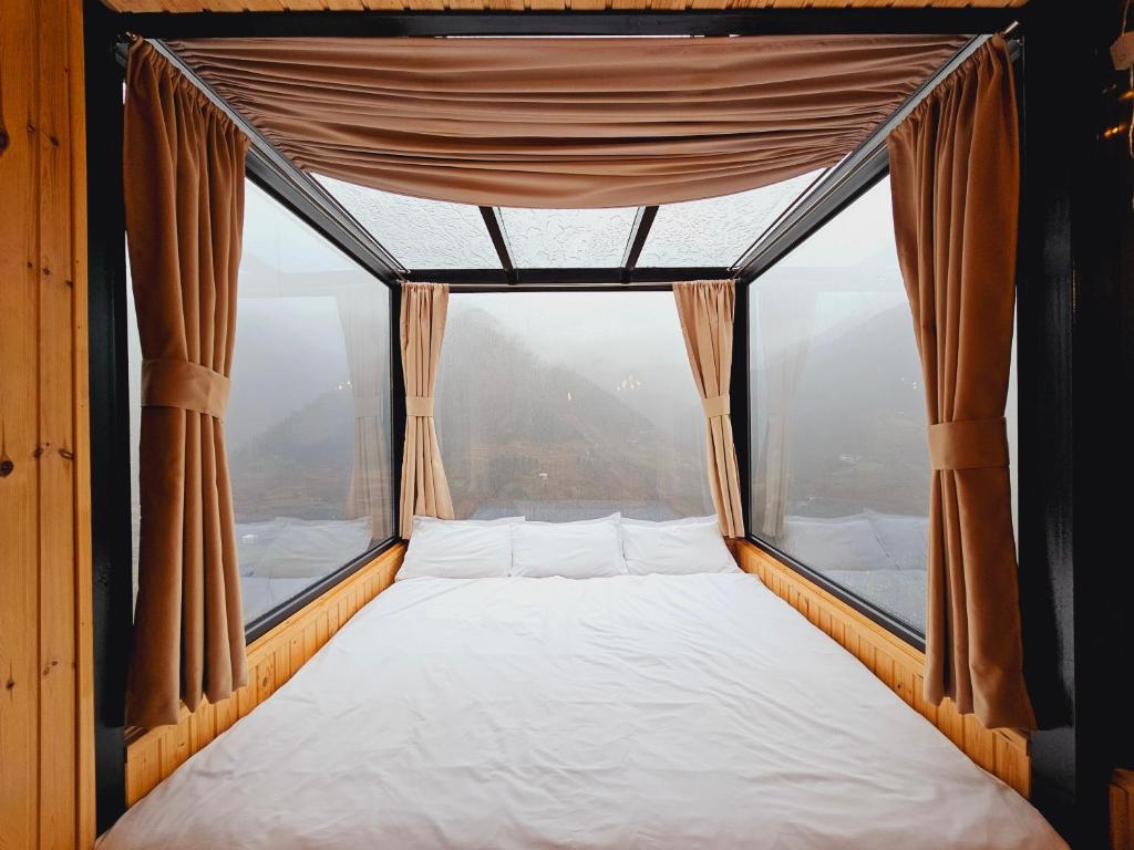 un letto in una camera con una grande finestra di Villa Machakhela a Batumi
