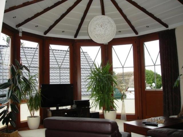 a living room with a couch and a tv and windows at Quartier 14 in Zempin