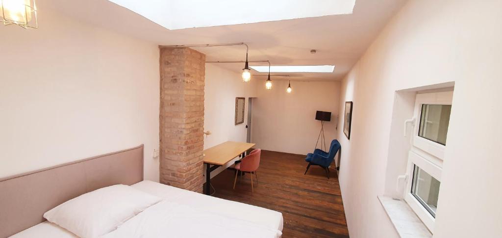 ein Schlafzimmer mit einem Bett und einem Schreibtisch in einem Zimmer in der Unterkunft Helles Zimmer im Loft in Mannheim