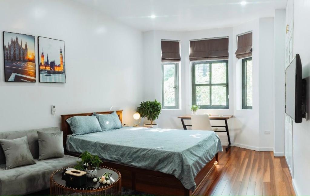een slaapkamer met een bed en een bank bij Chuỗi căn hộ Shan Apartment & Homestay - Vinhomes Imperia Hải Phòng in Hai Phong