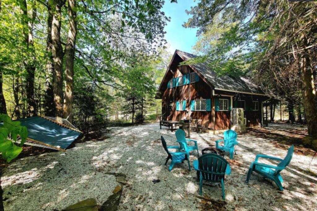a group of blue chairs in front of a cabin at 3 BR Centrally Located Poconos Chalet in Tobyhanna