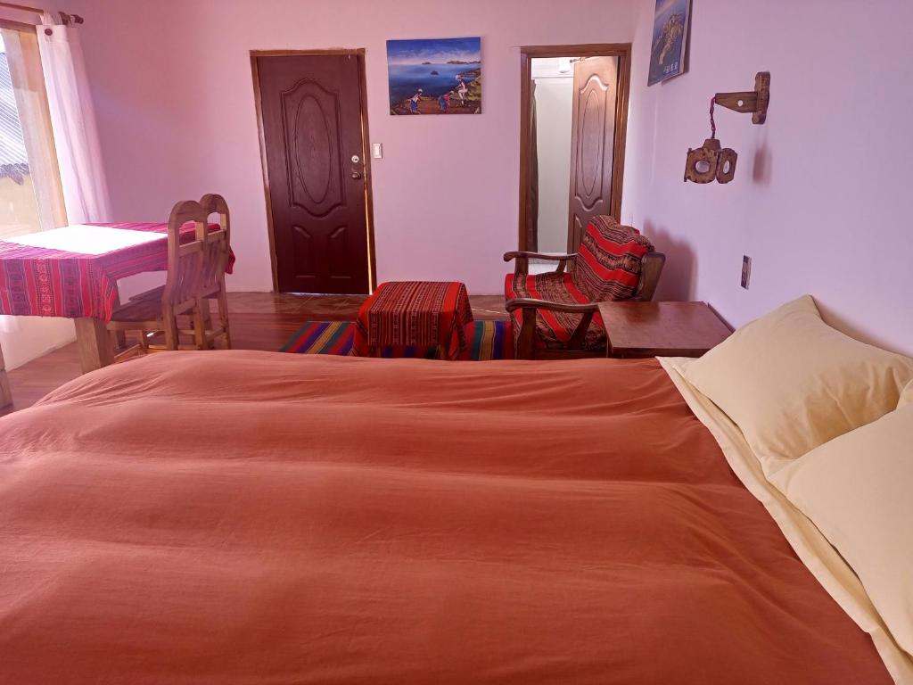 a bedroom with a bed and a table and chairs at CAMPO SANTO in Comunidad Yumani