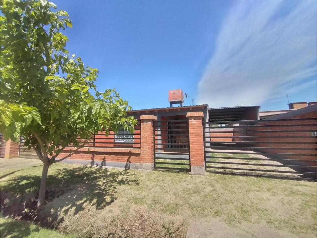 a brick building with a tree in front of it at Cabaña San Cayetano v&g in San Rafael