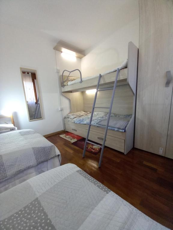 a bedroom with two bunk beds and a mirror at Villa Nani in Pieve di Cadore