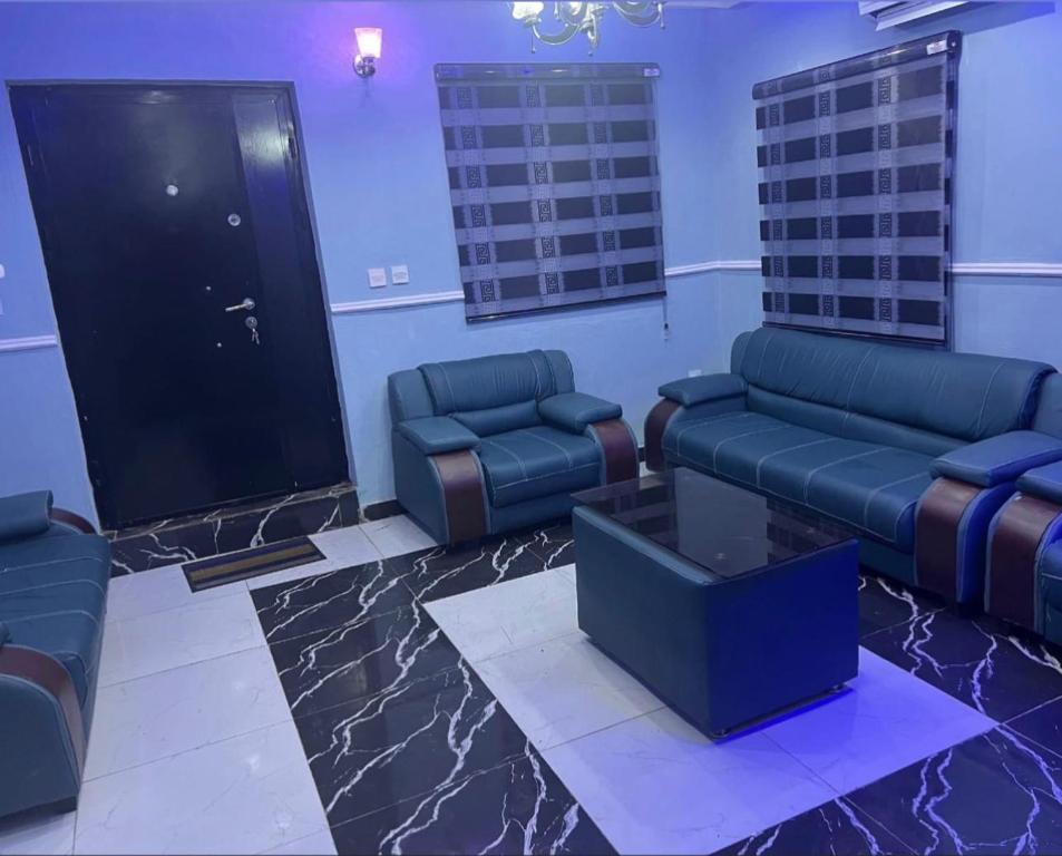a waiting room with couches and a table and a door at Muniz Apartments in Lagos