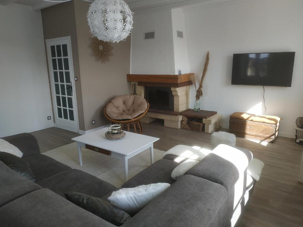 sala de estar con sofá y mesa en GRAND APPARTEMENT COSY DANS MAISON DE CAMPAGNE, en Saint-Pierre