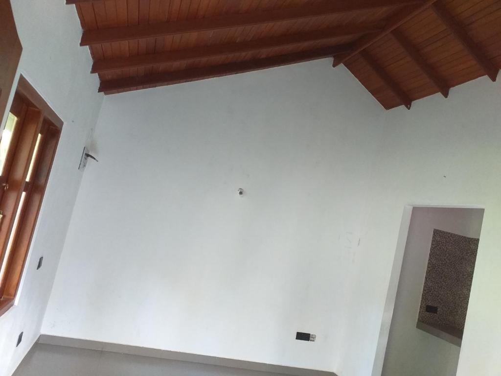 a room with a white wall and a wooden ceiling at Bel vedere in Minuwangoda