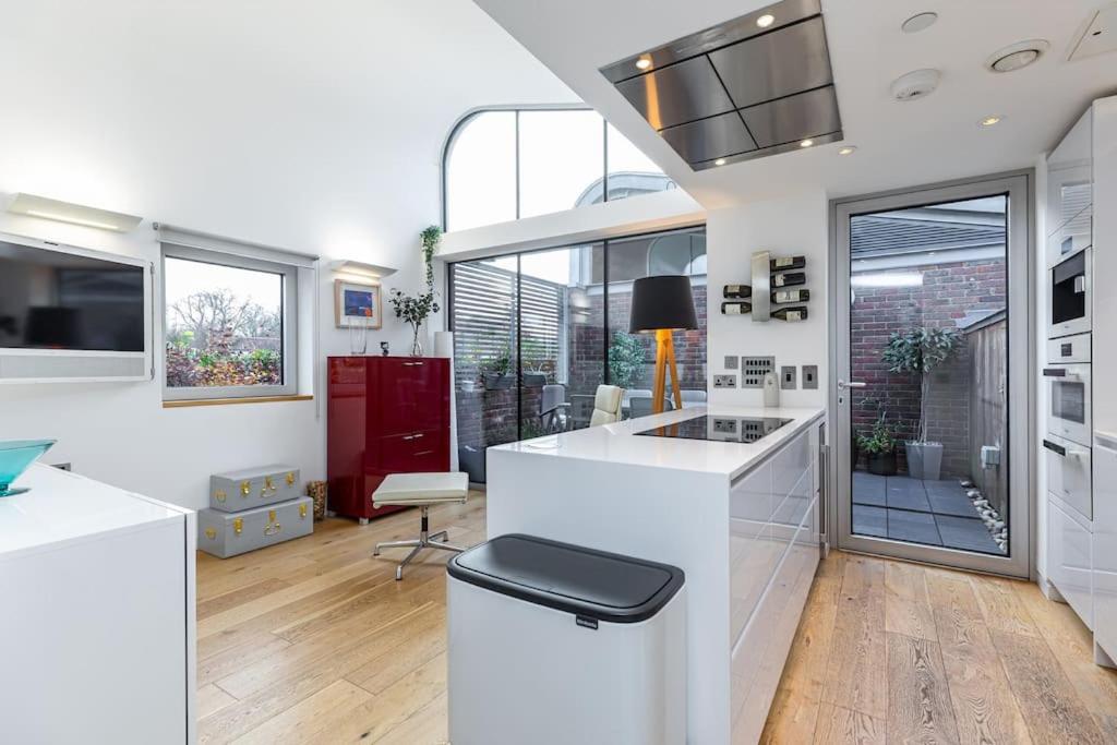倫敦的住宿－Stylish house with superb space，一间带白色柜台和大窗户的厨房
