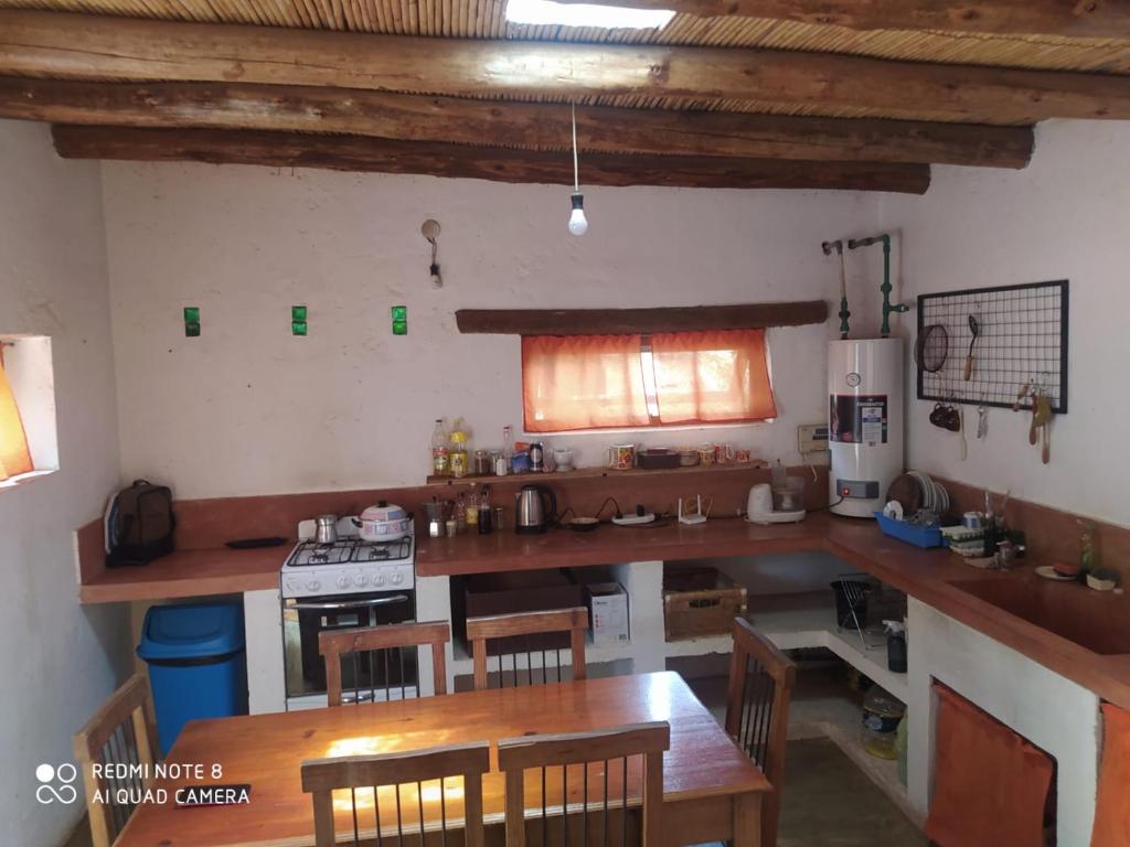 una cocina con encimeras de madera, mesa y sillas en Cabaña El Paraíso en Tinogasta