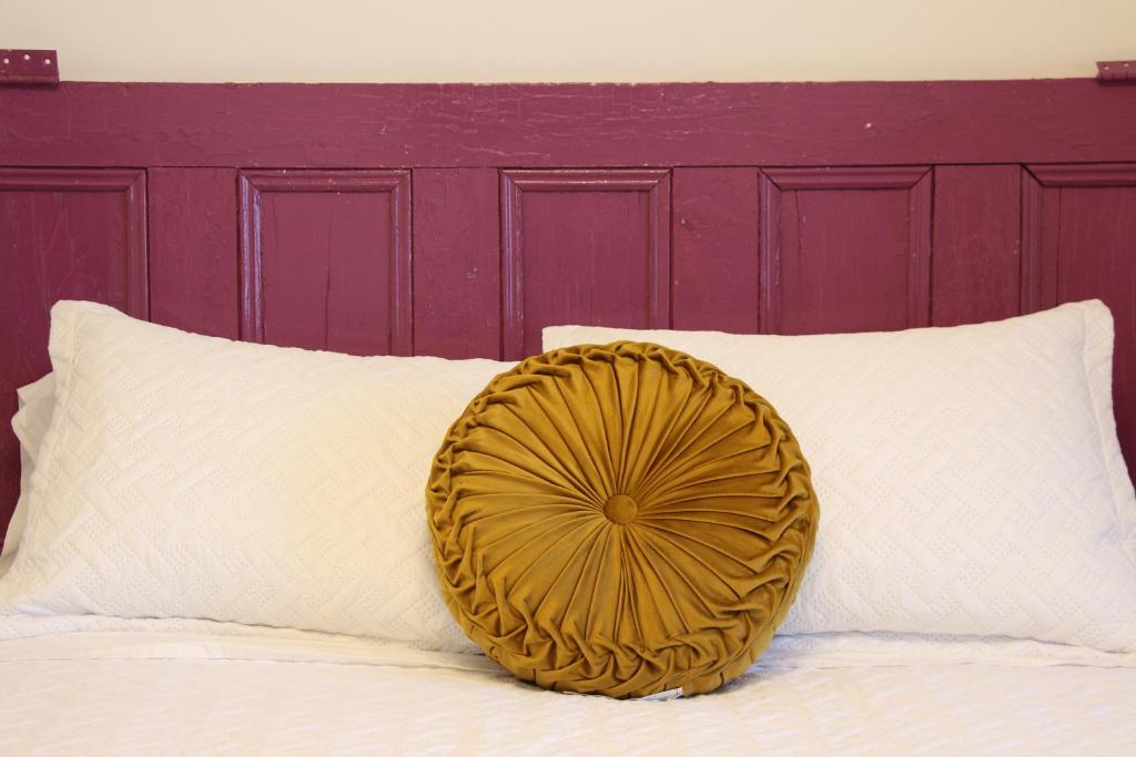 a yellow pillow sitting on top of a bed at 4 Guest Suite with Waterfront Views at Fancie's PEC in Belleville