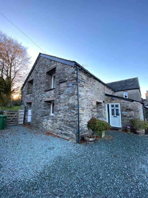 an old stone house sitting on a pile of gravel at The Drumlins Cottage in Ulverston