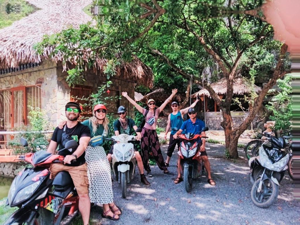 a group of people sitting on motorcycles in front of a house at Hang Mua Eco Garden in Xuân Sơn