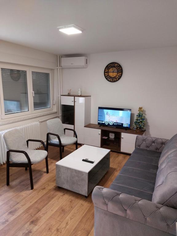a living room with a couch and chairs and a tv at Apartman Aura Prijedor in Prijedor