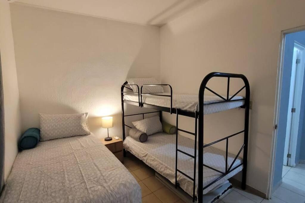 - une chambre avec deux lits superposés et un lit dans l'établissement Vivienda familiar, à San Miguel