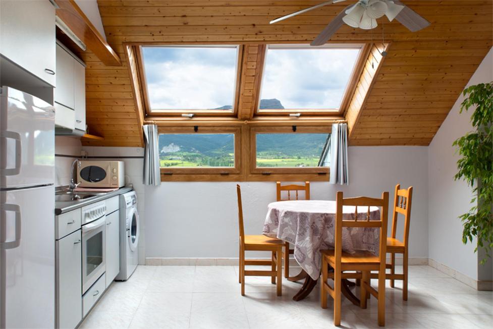 a kitchen with a table and chairs in a kitchen at Apartamento Pico Aspe in Jaca