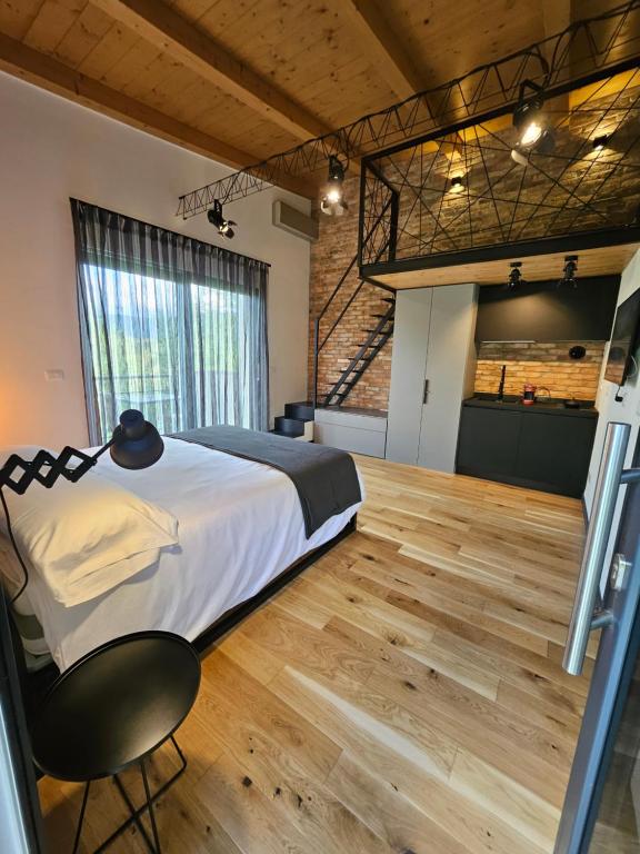 um quarto com uma cama grande e piso em madeira em GiardinidiEva Loft em Gorizia