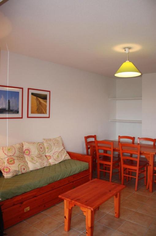 a living room with a couch and a table and chairs at Résidence Goélia Le Cordouan in Soulac-sur-Mer