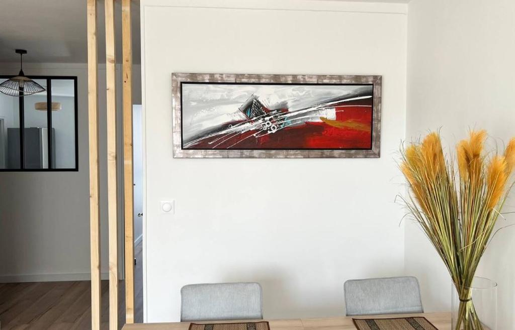 - un salon avec deux chaises et une photo sur le mur dans l'établissement Spacieux T2 idéalement placé, à Toulouse