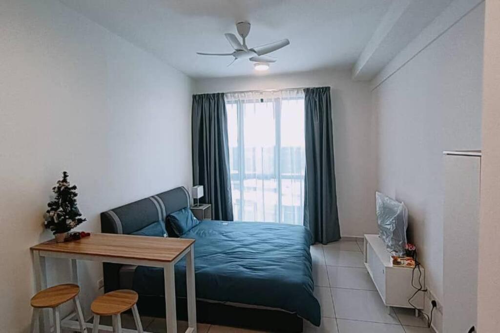 a living room with a blue bed and a table at Cozy Sky Trees Bukit Indah Nflix HBO Disney l Pool B8 in Johor Bahru