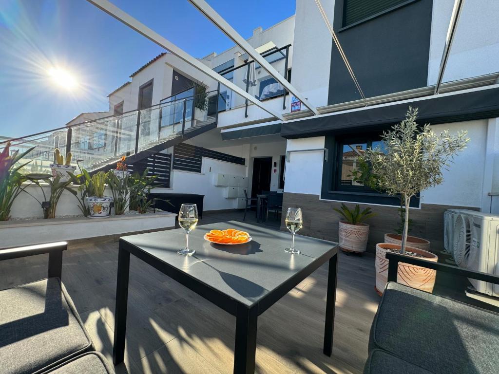 einen Balkon mit einem Tisch und 2 Gläsern Wein in der Unterkunft La Zenia Boulevard & Beach House in Orihuela