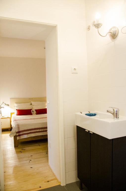 a bathroom with a sink and a bed in the background at Pensao Sisudo in Sintra