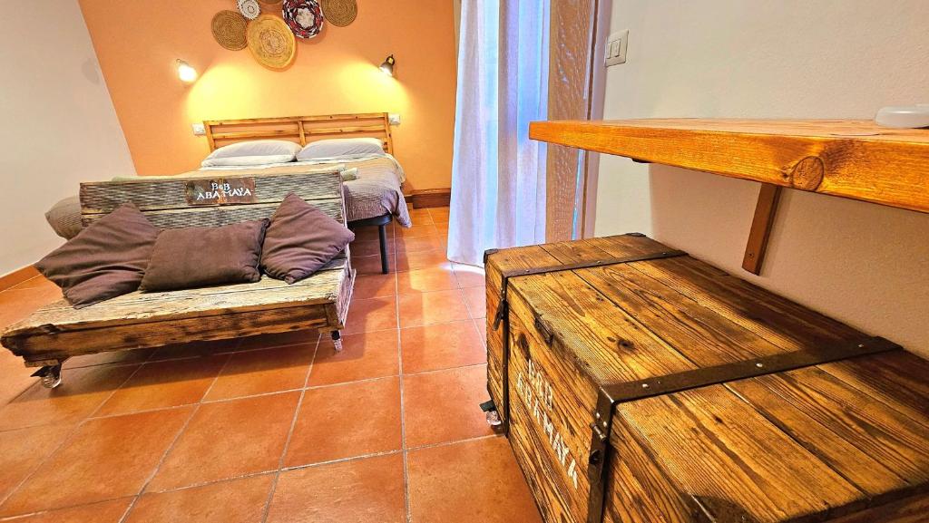 Zimmer mit 2 Betten, einem Sofa und einem Tisch in der Unterkunft Aba Maya Alghero in Alghero