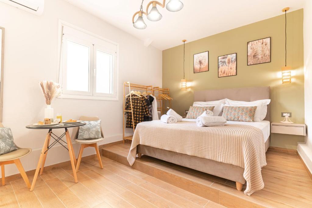 a bedroom with a large bed and a table at Olympian Goddess Demetra in Heraklio Town