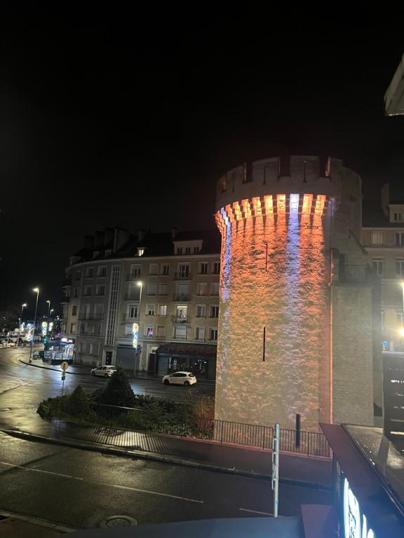 Un grand bâtiment avec des lumières allumées la nuit dans l'établissement Spa jacuzzi Caen centre, à Caen