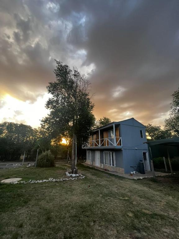 a house with a tree in the yard at Complejo La Rosa Molinari Cosquin in Córdoba