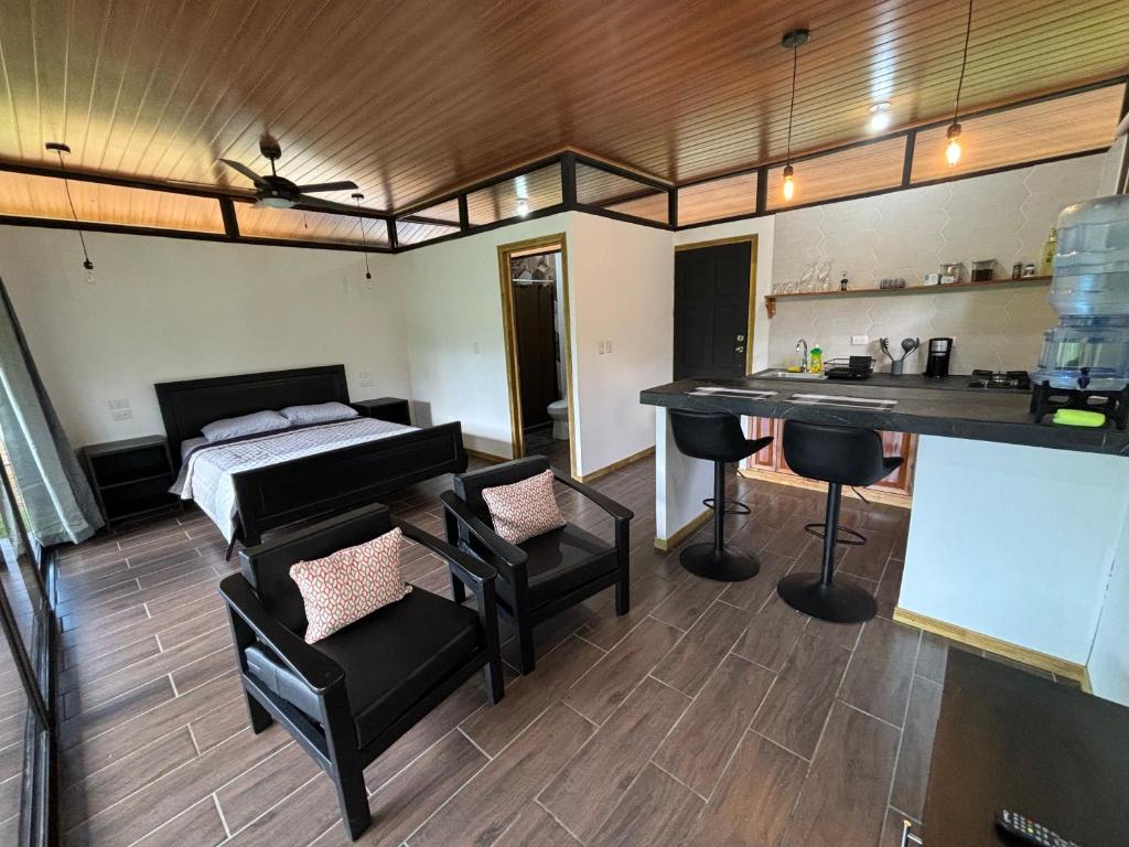 Habitación con cama, mesa y sillas. en Pacheco Tours Rainforest Cabins, en Drake