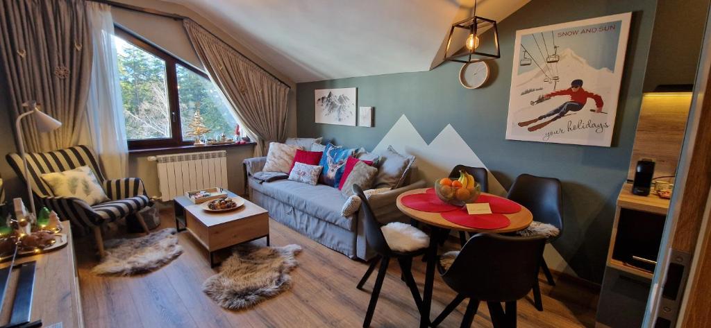 un soggiorno con divano e tavolo di PinePino Borovets, aparthotel Borovets Gardens A60 a Borovets