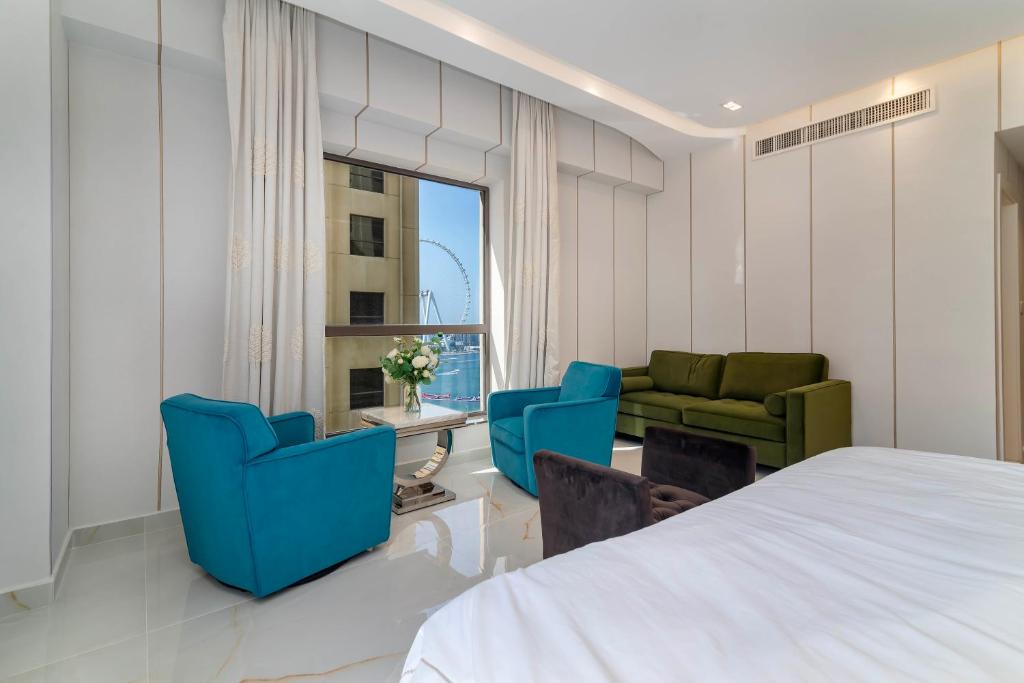 a bedroom with a bed and chairs and a window at Usmans 4BDRM APARTMENT SEA VIEW Rimal in Dubai