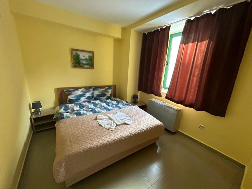1 dormitorio con 1 cama con toallas en Хотел Тракия en Haskovo