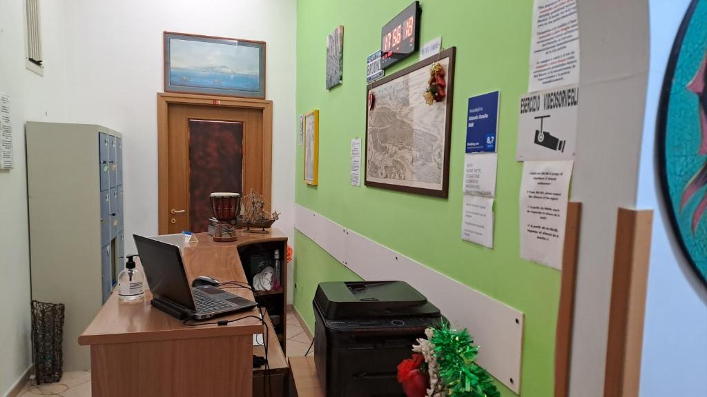 una oficina con escritorio y ordenador portátil en la pared en Atlantic Ostello B&B en Nápoles