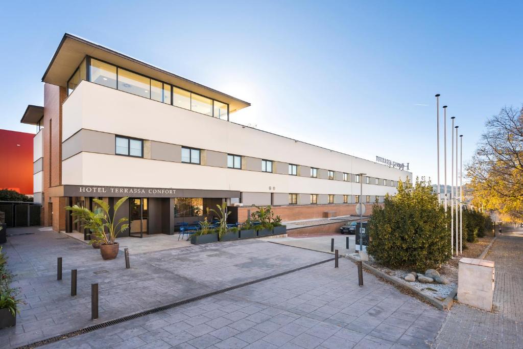 a large white building with plants in front of it at Hotel Terrassa Confort in Terrassa