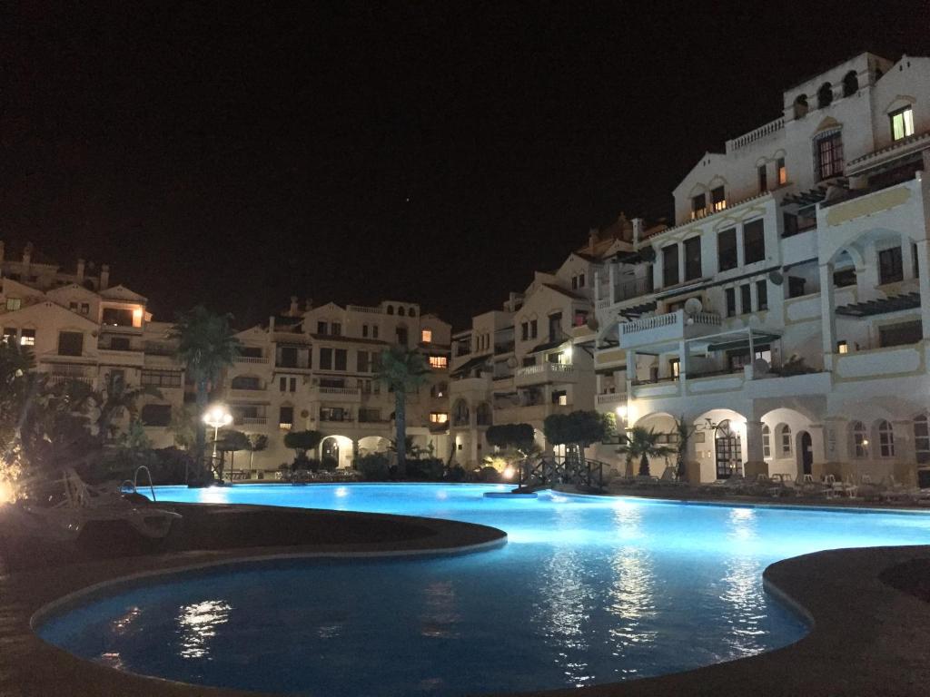 a large swimming pool at night with white buildings at Roquemar dreams 435 in Roquetas de Mar