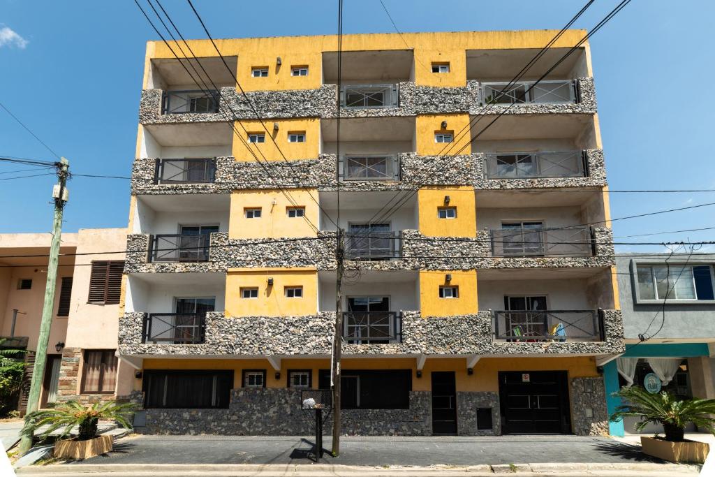 un edificio de apartamentos con puertas y ventanas amarillas en Palmeras Departamentos en Santa Teresita