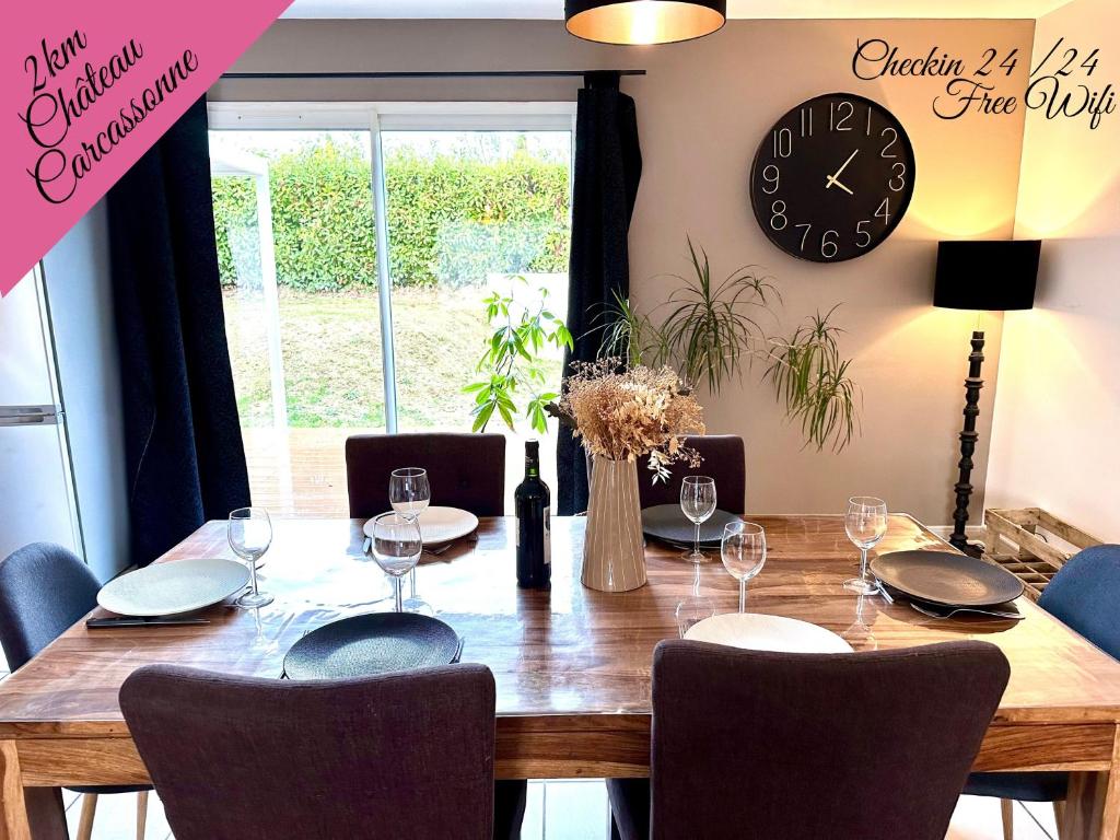 uma mesa de jantar com cadeiras e um relógio na parede em Agréable villa proche du Château de Carcassonne ! em Cazilhac