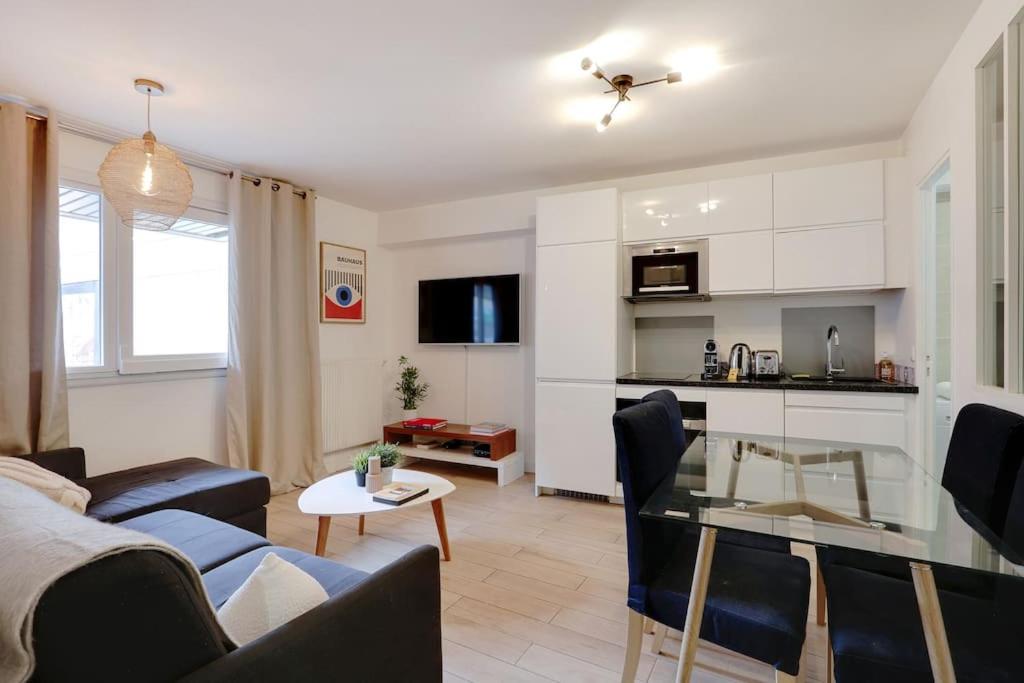 un salon avec un canapé et une table dans l'établissement Charming FLAT - Père Lachaise, à Paris