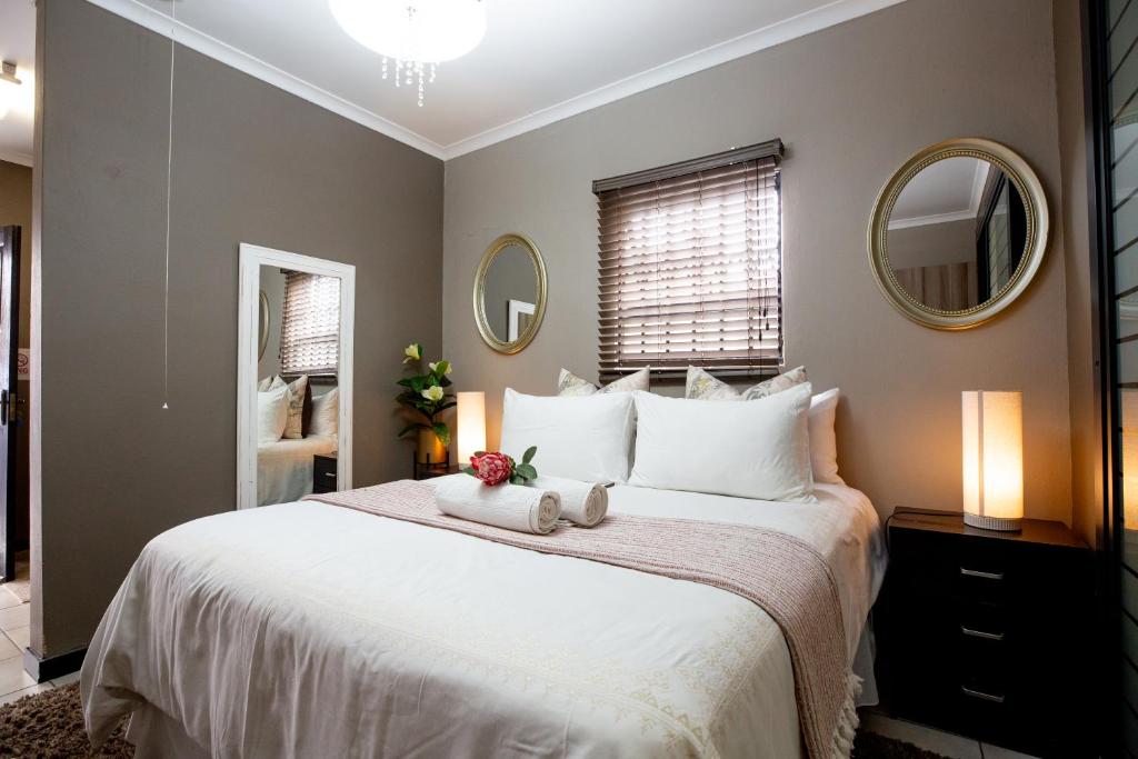 a bedroom with a large bed with two white pillows at URlyfstyle Cottage 10km from OR Tambo Int Airport in Kempton Park