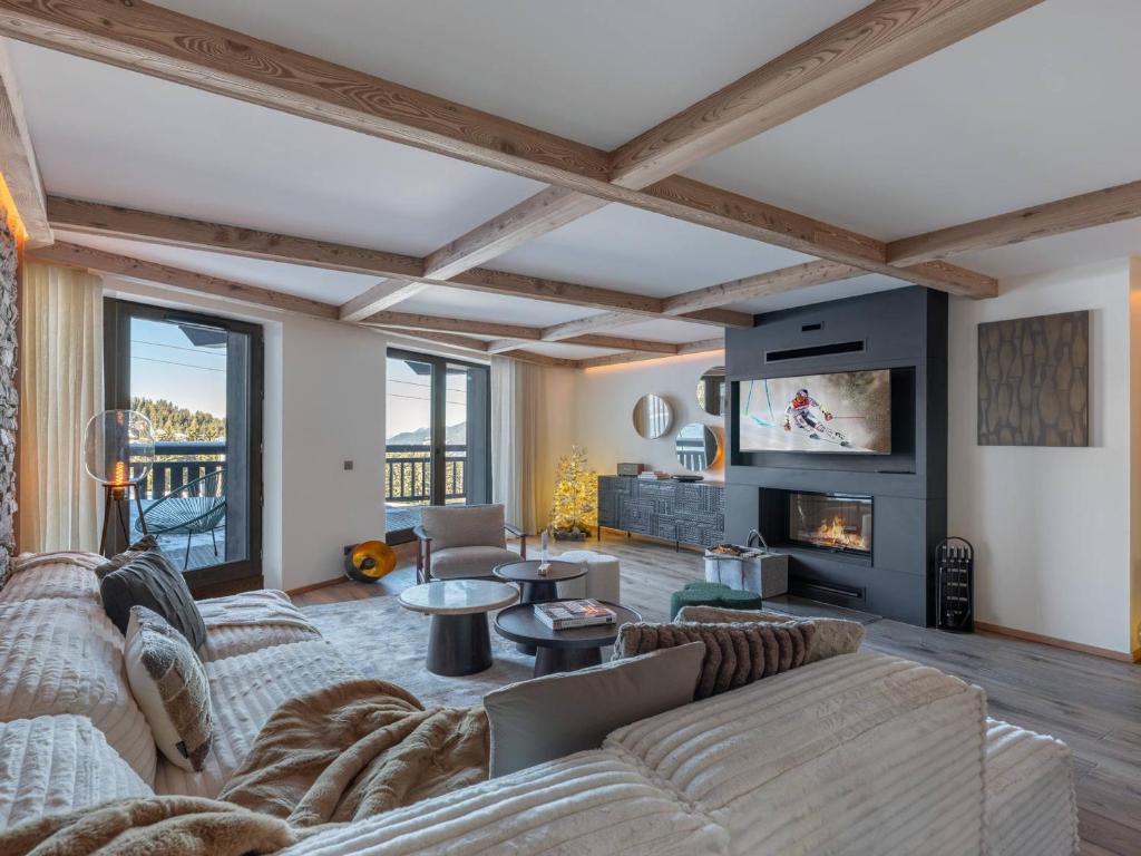 a living room with a couch and a fireplace at Appartement neuf à Courchevel 1850 avec accès direct aux pistes, piscine et SPA - FR-1-564-108 in Courchevel