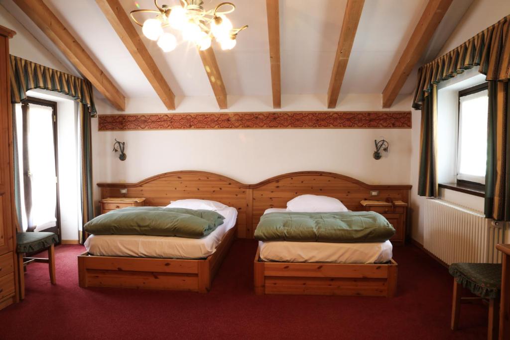 Postel nebo postele na pokoji v ubytování Dolomiti Hotel Cozzio