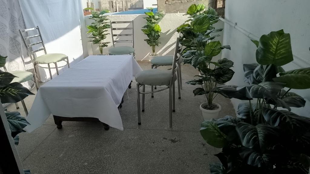 una mesa blanca y sillas en una habitación con plantas en HOTEL CLINK A Butique Airport Hotel en Nueva Delhi