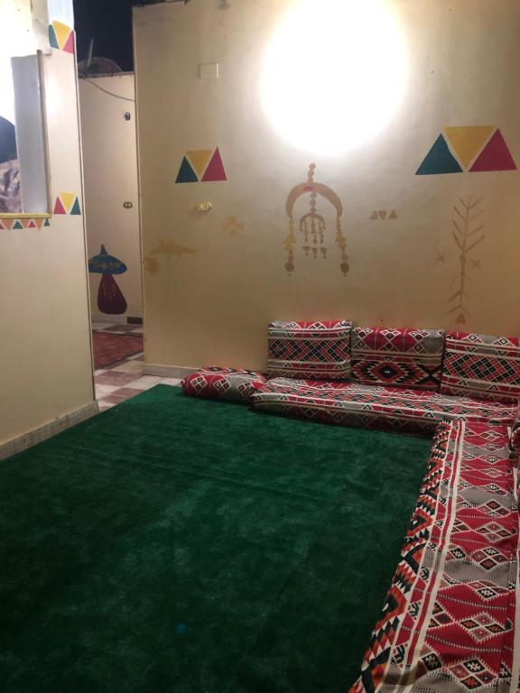 a room with a green carpet and a wall at NUB Guest House in Aswan