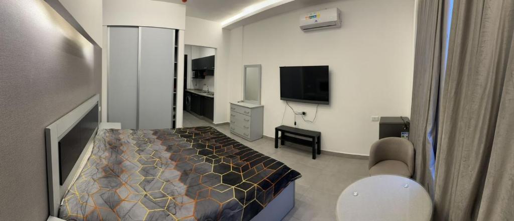 a bedroom with a bed and a television in it at Gentle Breeze Studio1 in Amman