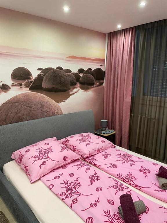 1 dormitorio con 2 camas y manta rosa en Igényes Lakás, en Szeged