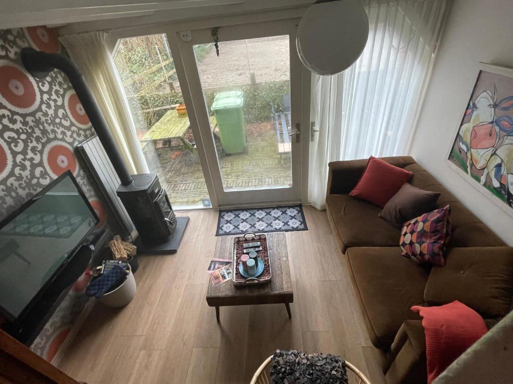 a living room with a couch and a tv at Apartment De Stranding in Egmond aan den Hoef